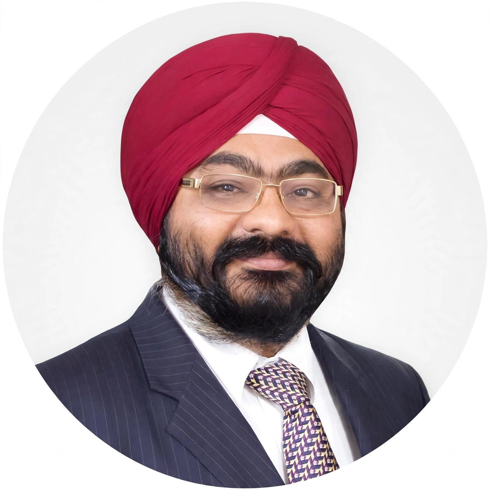 Portrait of Kamaljeet Singh Choudhary with his full red turban, tie and suit visible
